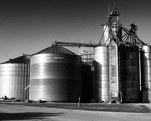grayscale-photo-of-silos